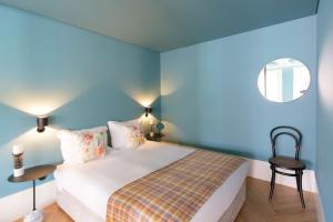 1 dormitorio azul con 1 cama y 1 silla en HM - Infante Riverside Apartment M en Oporto