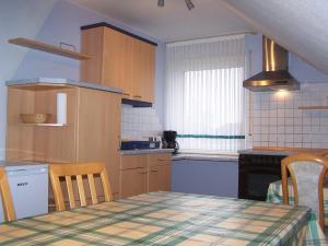 a kitchen with a table and a table and chairs at Ferienwohnung Mauer, Wohnung "A" in Heede