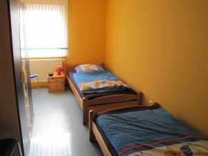 2 camas individuales en una habitación con ventana en Ferienwohnung Mauer, Wohnung "A", en Heede