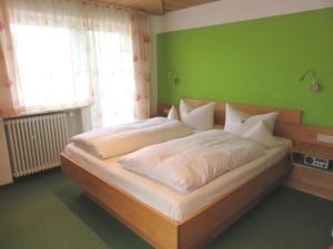 ein Schlafzimmer mit einem großen Bett und einer grünen Wand in der Unterkunft Ferienhaus Weiß, Sandra Weiß in Füssen