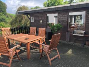 a picnic table and chairs in front of a tiny house at Ferienwohnung Donner am Wald mit Garten & Hot-Tub in Meschede