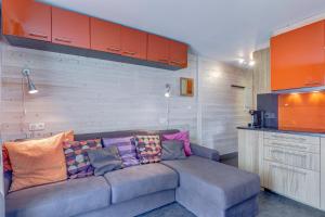 a living room with a gray couch with colorful pillows at Studio Cornaline - Studio aux pieds des pistes in Crest-Voland
