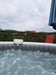 a hot tub on a balcony with a table and chairs at Vila la Izvorul Putinei in Haţeg +70 photos
