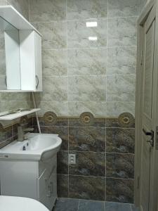 ein Badezimmer mit einem weißen Waschbecken und einem WC in der Unterkunft Sweet Home in Taschkent