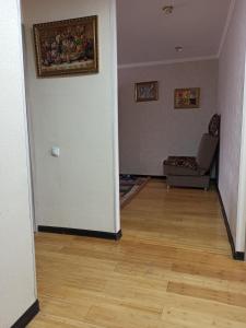 Sweet Home في طشقند: غرفه وصاله فيها كرسي ودهان على الحائط