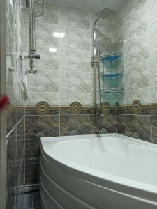 ein Badezimmer mit einer weißen Badewanne und einer Dusche in der Unterkunft Sweet Home in Taschkent