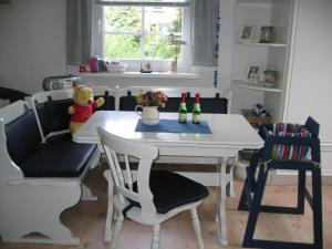 a kitchen with a table and chairs with bottles on it at Kinderfreundliche Ferienwohnung - Am Hufen 2 in Grömitz