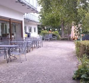 eine Gruppe von Tischen und Stühlen auf einer Terrasse in der Unterkunft Hotel Garni am Bowenberg in Niederzissen