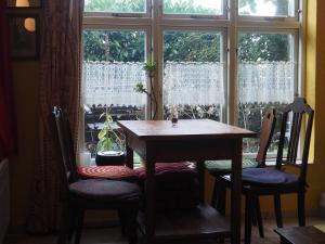 uma mesa e duas cadeiras em frente a uma janela em kleine Herta em Prerow