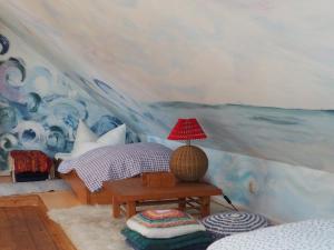 プレローにあるkleine Hertaの壁画のあるベッドルーム、ランプ付きのテーブル
