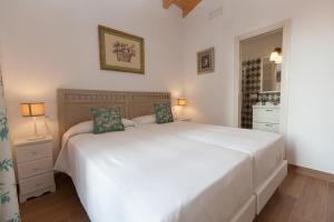 een slaapkamer met een groot wit bed en een spiegel bij Patios de la Riva in Jerez de la Frontera