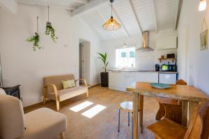 eine Küche und ein Wohnzimmer mit einem Tisch und Stühlen in der Unterkunft Casas Da Bica - Turismo Espaço Rural in Cercal