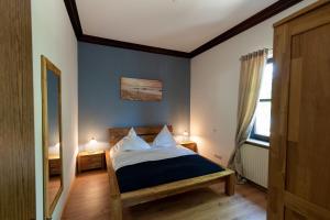 Un dormitorio con una cama con paredes azules y una ventana en Ferienwohnung EG, en Rödental