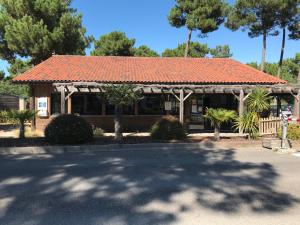 un bâtiment avec un toit en carrelage orange dans l'établissement Mobil-Home Camping Club 5* Montalivet, à Vendays-Montalivet