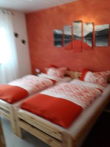 - 2 lits jumeaux dans une chambre aux murs rouges dans l'établissement Ferienwohnung-Zoe, à Saint-Wendel
