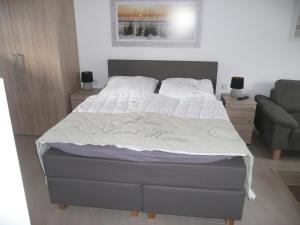 ein Schlafzimmer mit einem Bett mit einer weißen Bettdecke in der Unterkunft Burkert in Grömitz