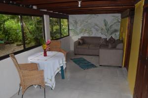 - une chambre avec une table, des chaises et un canapé dans l'établissement Haus mit trop Garten am Cahuita Nationalpark, à Comadre