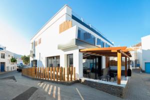 a white building with a table and chairs on a street at Hotel Cala Arena in San José