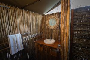 a wooden bathroom with a sink and a mirror at Boteti Tented Safari Lodge in Maun +37 photos