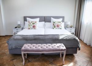 a bedroom with a large bed with a pink bench at Hotel Peñas Blancas in Liaño