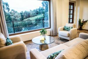 a living room with couches and a large window at Hotel Peñas Blancas in Liaño