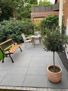 un patio avec des bancs, une table et un arbre dans l'établissement Mini-Ferienhaus Petersberg, à Eckernförde