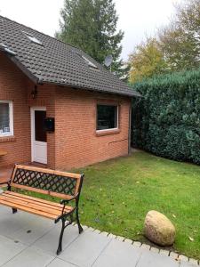 un banc assis devant une maison en briques dans l'établissement Mini-Ferienhaus Petersberg, à Eckernförde