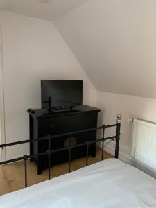 - une chambre avec une commode noire et une télévision à écran plat dans l'établissement Mini-Ferienhaus Petersberg, à Eckernförde