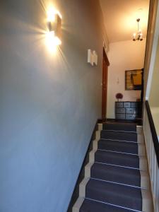 a hallway with a staircase with a blue wall at Morizan in Röbel