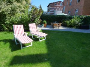 deux chaises assises dans l'herbe dans une cour dans l'établissement Morizan, à Röbel