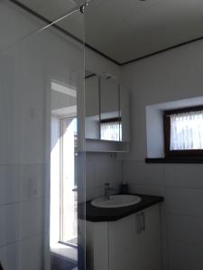 a white bathroom with a sink and a window at Bahnhofstraße 48 b in Kleinlangheim