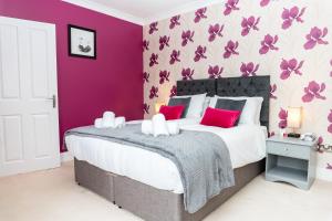 a purple bedroom with a large bed with red pillows at Red Cherry House in Watford