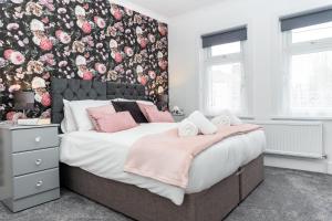 a bedroom with a bed with a floral wallpaper at Red Cherry House in Watford