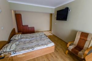 a small bedroom with a bed and a chair at OWiR Rejów in Skarżysko-Kamienna