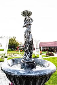 a statue of a woman with an umbrella in a fountain at Pensiunea Georgibel in Deva +17 photos