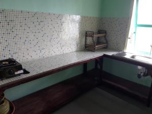 a bathroom with a counter with a sink and a window at Samikrasan Homestay in Tlekung