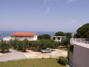samochód zaparkowany na podwórzu obok budynku w obiekcie Kastro Beach Hotel w mieście Kyllini