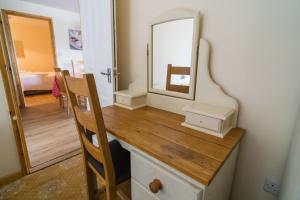 a bathroom with a dressing table with a mirror at The Pine Lodge in Aberystwyth