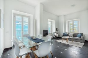 a white living room with a glass table and white chairs at Salty Sky Flat , Terre Marine in Corniglia