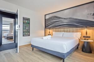 a hotel room with a large bed and a large window at Andante Hotel in Barcelona