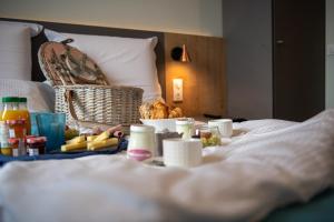 una bandeja de comida en una cama con una cesta de comida en Le Vivier en Amiens