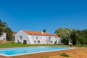 eine Villa mit einem Swimmingpool vor einem Haus in der Unterkunft Casas Da Bica - Turismo Espaço Rural in Cercal