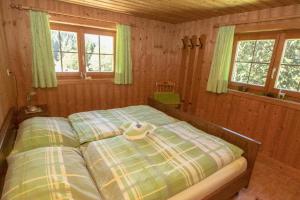 ein Schlafzimmer mit einem Bett in einem Zimmer mit Fenstern in der Unterkunft Haus am Reh in Gargellen