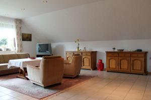 Emsland-Quartier في Bawinkel: غرفة معيشة مع طاولة وكراسي وتلفزيون