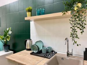 a kitchen counter with a sink and green tiles at Мини Гостиница Richotels in Ufa