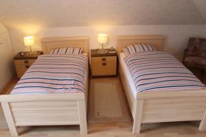 two beds in a room with two lamps on night stands at Emsland-Quartier in Bawinkel