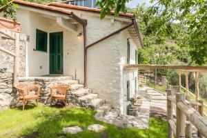 een stenen huis met een groene deur en twee stoelen bij Sound of Silence, Terre Marine in Corniglia