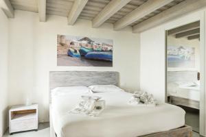 een witte slaapkamer met 2 bedden en een spiegel bij Sound of Silence, Terre Marine in Corniglia