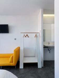 a living room with a yellow couch and a desk at Bela Muxía in Muxia