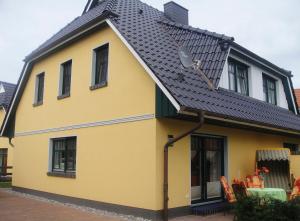 ツィングストにあるGödeke Michels 2の黒屋根の黄色い家